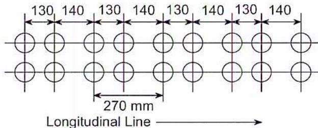 Diagram showing two rows of tube holes with unequal pitch. The pitch alternates between 130 mm and 140 mm. A horizontal arrow below the holes is labeled 'Longitudinal Line'. A dimension line below the holes indicates a distance of 270 mm.