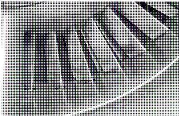 Close-up photograph of the inlet guide vanes (IGVs) of a Rolls Royce RB211 Gas Turbine. The image shows several curved, metallic blades arranged in a circular pattern, with a dark, textured background.