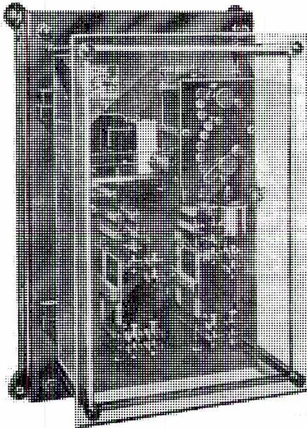 A black and white photograph of an indirect-acting rheostatic regulator. The device is a rectangular box with a transparent front panel, revealing a complex internal mechanism. This mechanism includes a motor, a cam, and various electrical contacts and wiring. The unit is mounted on a dark, possibly metallic, base or frame.