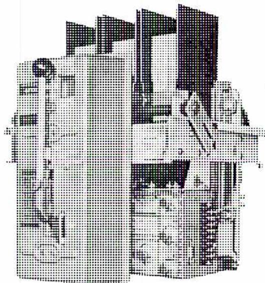 A black and white photograph of a large, three-pole air circuit breaker. The device is a complex mechanical assembly with three vertical poles. On the front, there is a large operating handle on the left and a smaller closing lever on the right. Various mechanical components, including springs and linkages, are visible on the right side of the unit.
