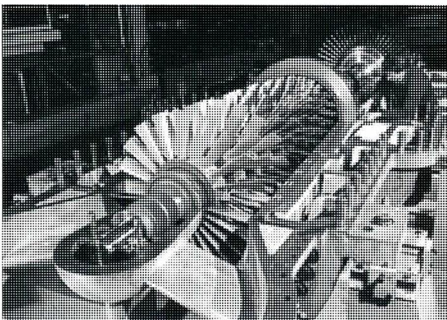 A black and white photograph showing a close-up, angled view of an axial flow compressor. The image displays multiple rows of curved blades (rotor and stator) arranged within a cylindrical casing. The lighting creates highlights and shadows on the metallic surfaces, emphasizing the aerodynamic shape of the blades.